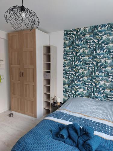 - une chambre avec un lit bleu et un grand mur de poissons dans l'établissement Studio pour deux - WiFi, à Dijon