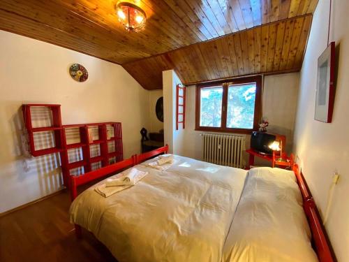 une chambre avec un grand lit avec un plafond en bois dans l'établissement Ski runs - Sweet Vintage Home, à Bardonnèche