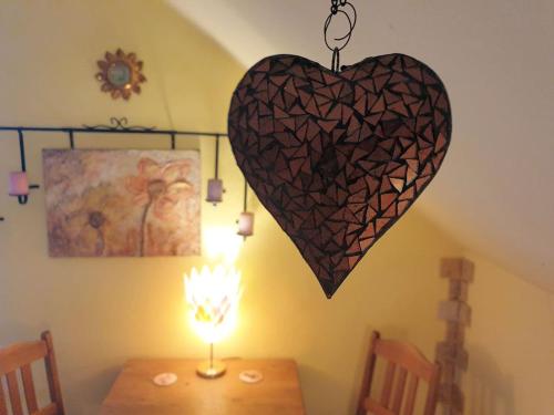 Un corazón colgado en una pared junto a una mesa. en Privatzimmer Tenerife, en Moers