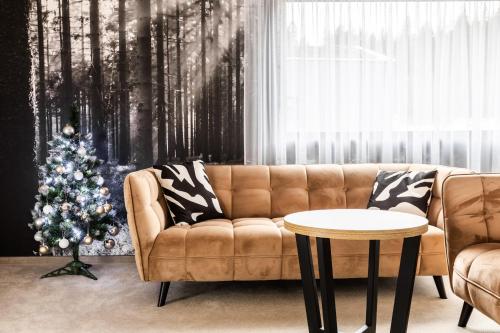 a living room with a christmas tree and a couch at Malino Resort & Residences - Ski and Bike Apartments in Ružomberok