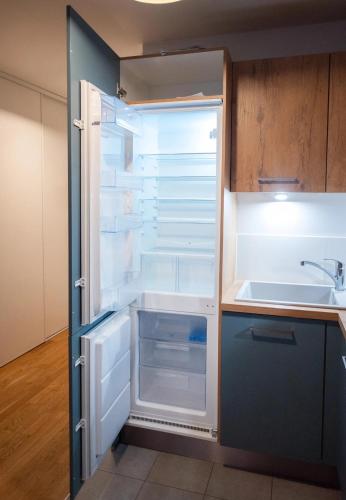 un réfrigérateur vide avec sa porte ouverte dans une cuisine dans l'établissement Sérénité totale : appartement ensoleillé, à Clichy