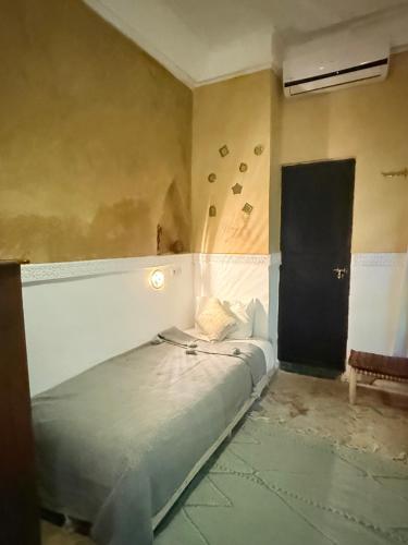 a bed in a room with a black door at Riad Dama & Spa in Marrakech