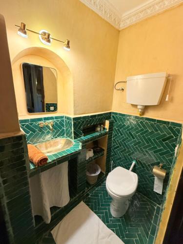 a bathroom with a toilet and a sink and a mirror at Riad Dama & Spa in Marrakech
