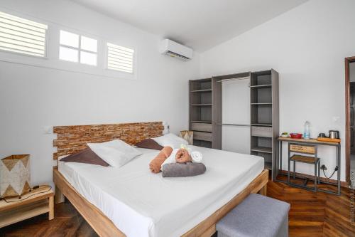 a bedroom with a bed with a teddy bear on it at Sublime Villa Piscine - Trésor de la Baie in La Trinité