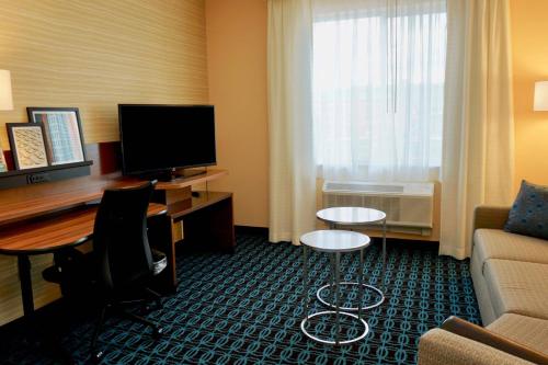 a hotel room with a desk and a couch and a computer at Fairfield by Marriott Inn & Suites Jonestown Lebanon Valley in Jonestown