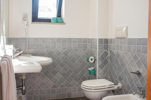 a bathroom with a sink and a toilet and a mirror at Villaggio Spiagge Rosse in Capo Rizzuto