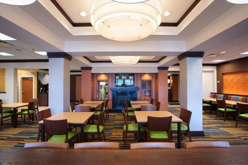 a restaurant with tables and chairs and a chandelier at Fairfield Inn & Suites Orange Beach in Orange Beach