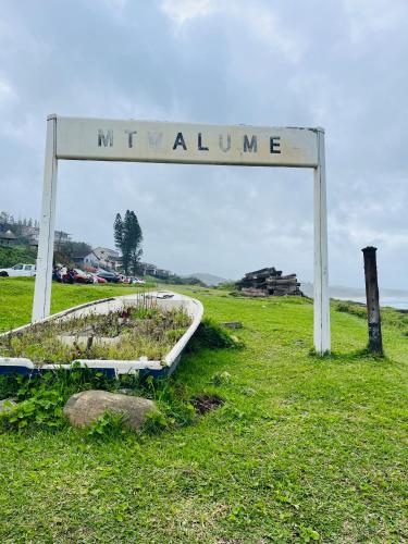 a sign that reads mwilamine in a field at Emanzini Self-catering guesthouse in Mtwalume