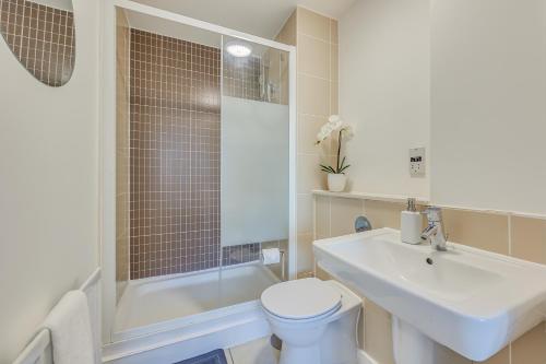 une salle de bain avec un lavabo, des toilettes et une douche dans l'établissement Stunning City Centre Apartment with Balcony, Free Parking, Fast Wifi and SmartTVs by Yoko Property, à Milton Keynes