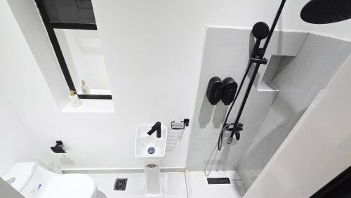 a white bathroom with a toilet in a room at Oasis Moods Holiday Homes in Al Ain