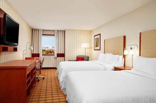 a hotel room with two beds and a flat screen tv at Four Points by Sheraton Edmonton South in Edmonton