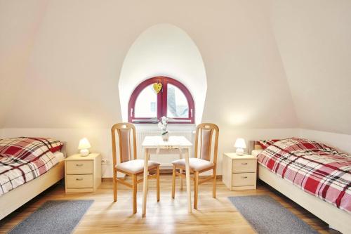 een slaapkamer met twee bedden en een tafel en stoelen bij Seemöwe in Glowe