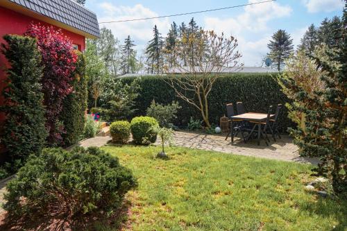 a garden with a table and chairs next to a hedge at Wellenreiter in Stahlbrode