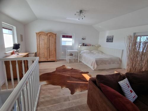 une chambre avec un lit et un parquet dans l'établissement Nordlicht, à Hamburgerdeich