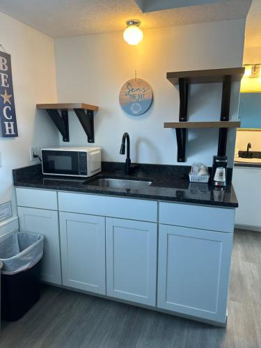a kitchen with a sink and a microwave at Nautical Motel in Hampton