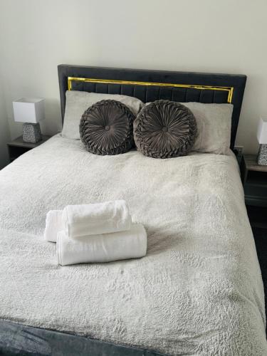 a bed with two towels and two pillows on it at Harmony House 3 Bedroom New Build for Families, Contractors, Black Country Museum Sleeps 6 in Tipton