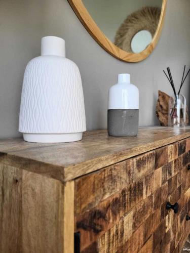 deux vases assis sur une table en bois avec un miroir dans l'établissement Résidence Port Bourgenay - maeva Home - Appartement 2 pièces 4 personnes - Exclusive - super Home MAE-5321, à Talmont-Saint-Hilaire
