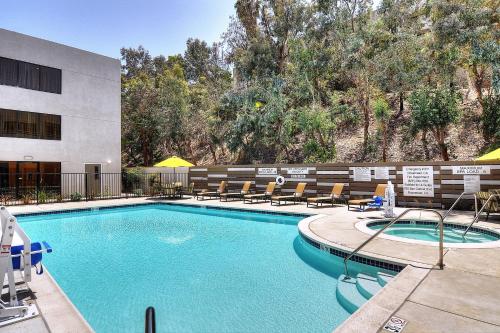 a pool at a hotel with chairs and a building at Fairfield Inn & Suites by Marriott Los Angeles Rosemead in Rosemead