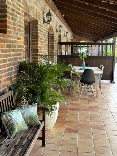 a patio with a bench and a table with plants at Domaine du Château in Les Trois-Îlets