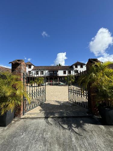 an open gate to a house with palm trees at Domaine du Château in Les Trois-Îlets