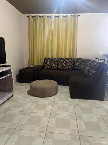 a living room with a black couch and a tv at Casa Refúgio da Paz in Lumiar
