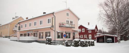 um edifício com neve no chão à sua frente em Dala-Järna Hotell och Vandrarhem em Dala-Järna