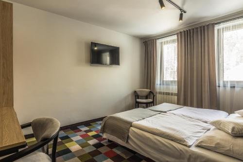 a hotel room with a bed and a desk at OSW Pan Tadeusz in Krynica Zdrój