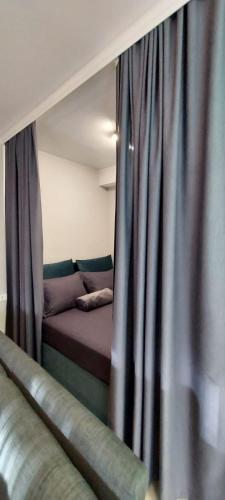 a bed in a room with blue curtains at Apartman Tivat - Centar 1 in Tivat