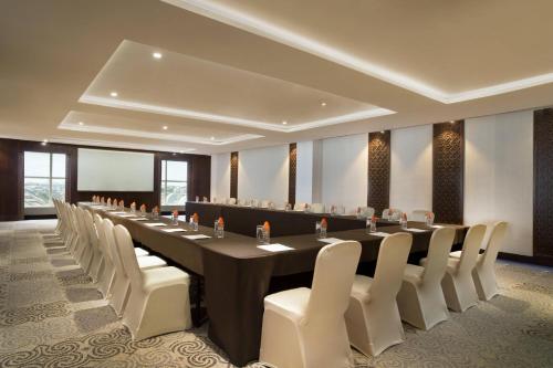 a large conference room with a long table and white chairs at Four Points by Sheraton Makassar in Makassar