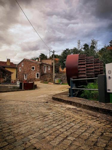 a large red object is sitting on the side of a street at Casa Iris Cunqueiros in Sobreira Formosa