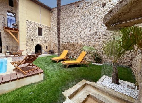 a yard with chairs and a pool and a building at Villa Eleonore - Chic Central Retreat Heated Pool in Monségur