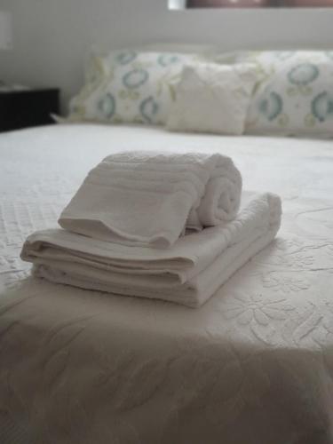 a pile of towels sitting on top of a bed at Casa Iris Cunqueiros in Sobreira Formosa