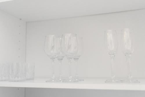 a row of wine glasses sitting on a shelf at Pilot Loft in Kaunas