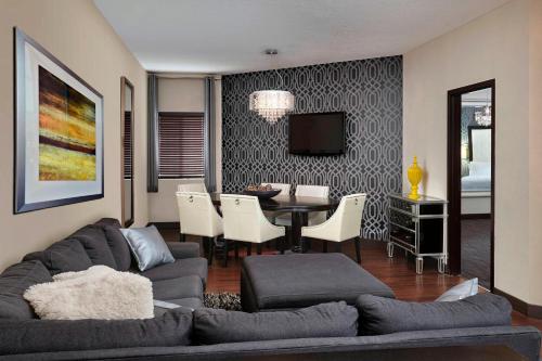 a living room with a couch and a dining room at Four Points by Sheraton Hotel & Suites Calgary West in Calgary