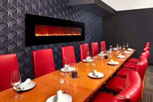 a conference room with a long table and red chairs at Four Points by Sheraton Hotel & Suites Calgary West in Calgary
