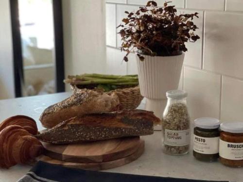 a table with bread and a vase with a plant at Suite with sea view in Sölvesborg in Sölvesborg