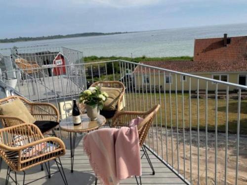 a balcony with chairs and a table with a view of the ocean at Suite with sea view in Sölvesborg in Sölvesborg