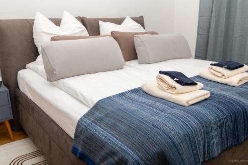 a bed with towels and pillows on top of it at Willkommen im Taros Home - Deluxe Apartment, der Wohlfühl Oase mit Balkon, HiFi Music, Coffee, 3 Betten und Homeoffice Platz in Herrenberg
