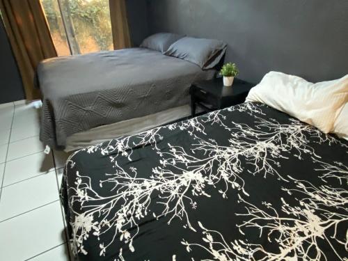 two beds sitting next to each other in a bedroom at Departamento con vista al jardín in Tijuana
