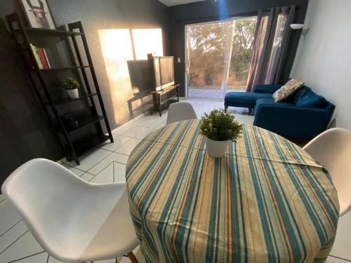 a living room with a table and chairs and a couch at Departamento con vista al jardín in Tijuana