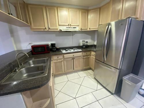 a kitchen with a stainless steel refrigerator and a sink at Departamento con vista al jardín in Tijuana