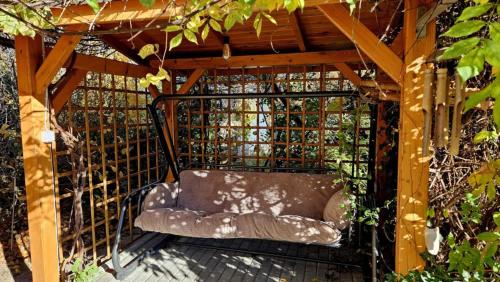 a couch sitting under a wooden pergola at Zakątek u Poety Dąbrówka in Jasło