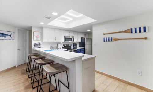 a kitchen with a counter and bar stools at Ground Floor Beachfront 2 Steps From Amenities IV in South Padre Island