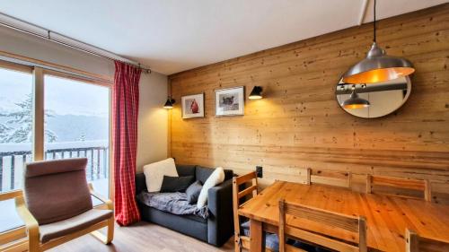 - un salon avec des murs en bois, une table et un canapé dans l'établissement Résidence Castor - Appartement confortable · Proche des pistes · Balcon MAE-7387, à Flaine