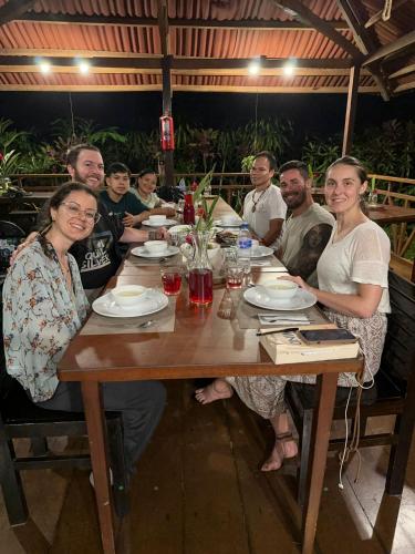 a group of people sitting around a wooden table at Casa Amazonas in Puerto Maldonado