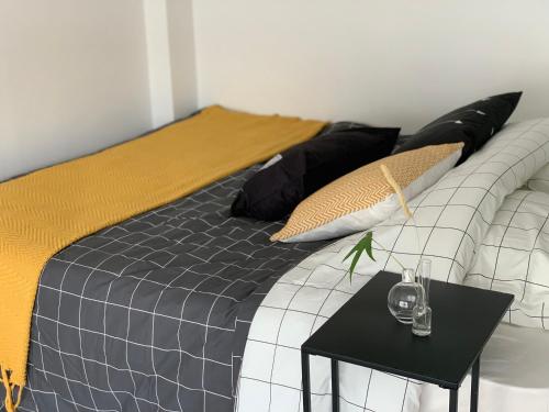 - un lit avec des oreillers en noir et or et une table dans l'établissement Nice dupleix 5mins walk to gare monparnasse, à Paris