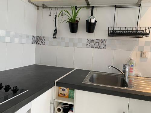 une cuisine avec des armoires blanches et un évier dans l'établissement Nice dupleix 5mins walk to gare monparnasse, à Paris