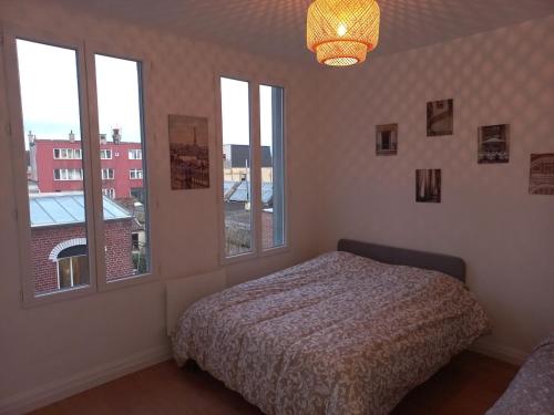 une chambre avec un lit et deux fenêtres dans l'établissement Appt 11 T3 Cateau Agréable et Calme, à Roubaix