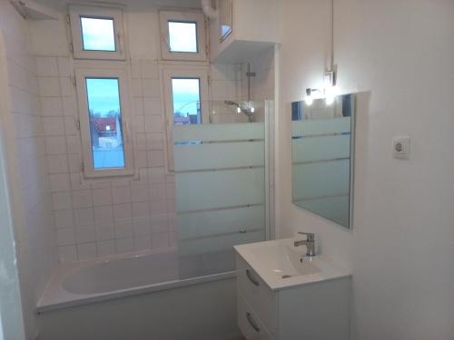 une salle de bain avec un lavabo, une baignoire et des toilettes dans l'établissement Appt 11 T3 Cateau Agréable et Calme, à Roubaix