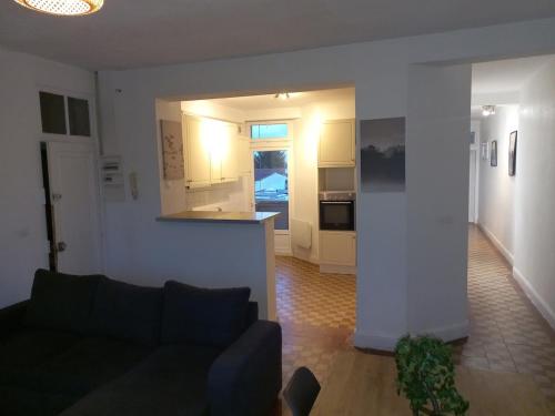 un salon avec un canapé et une cuisine dans l'établissement Appt 11 T3 Cateau Agréable et Calme, à Roubaix